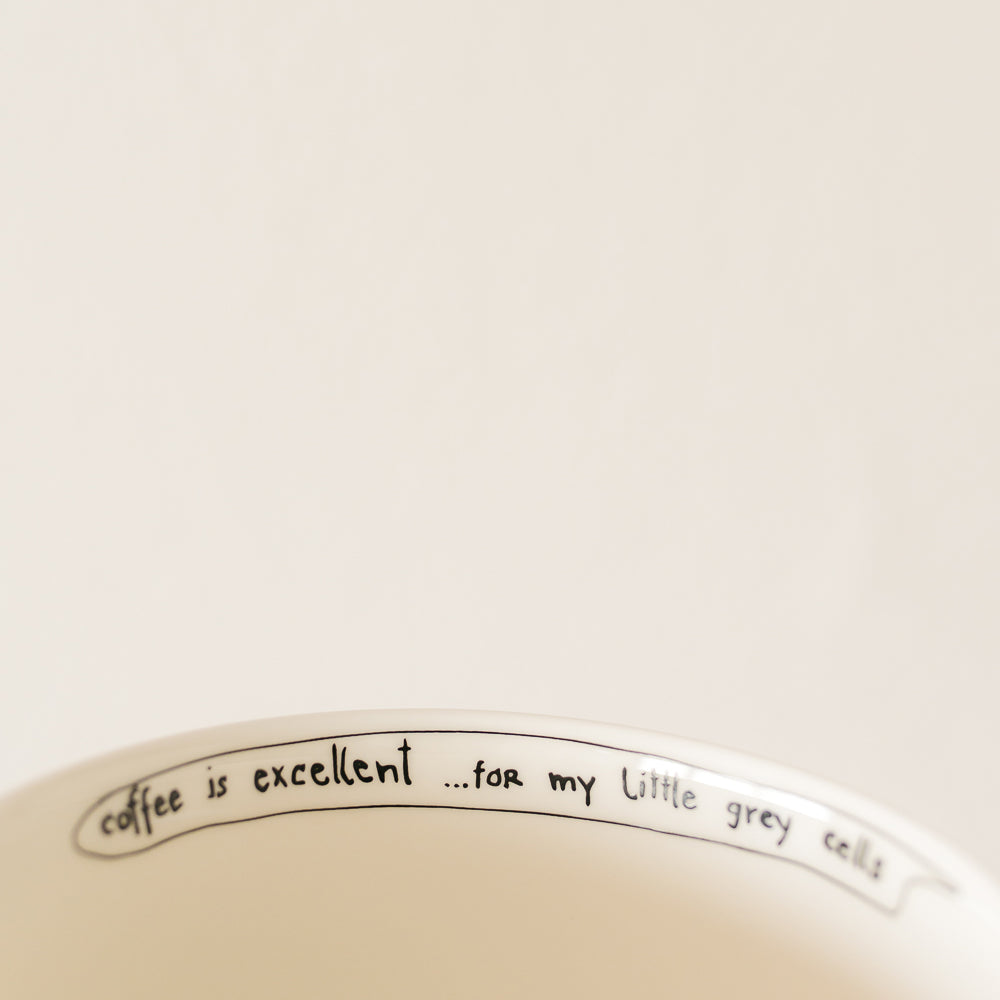 witty handwritten caption on an inner rim of  porcelain cup