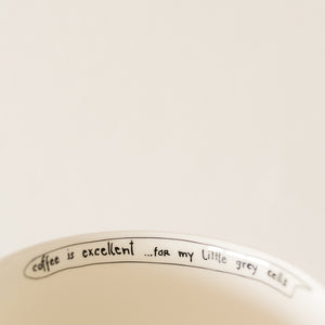 witty handwritten caption on an inner rim of  porcelain cup